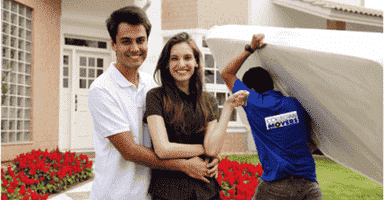 Moving home: Couple infront of new house with Collegian Movers moving them in.