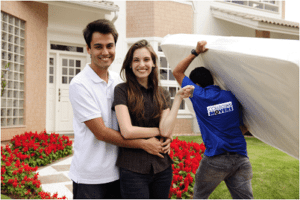 Moving home: Couple infront of new house with Collegian Movers moving them in.