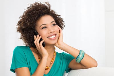 Portrait Of Young Girl Talking On phone Sitting on Couch Talking to Phone Company