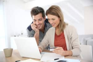 Couple reviewing a furniture moving cost estimate with a computer on a desk, symbolizing budget considerations.