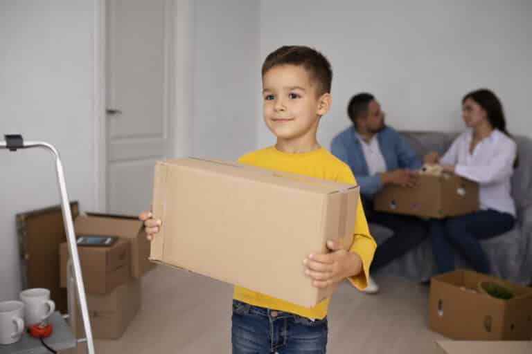 A boy carrying a moving box
