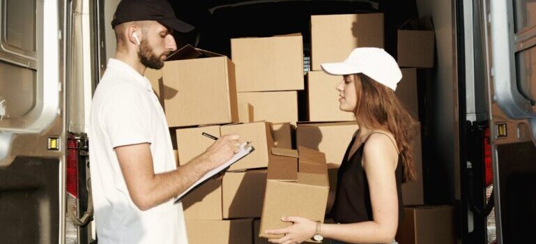 A man and woman putting boxes into a van and waiting for movers Shelton CT