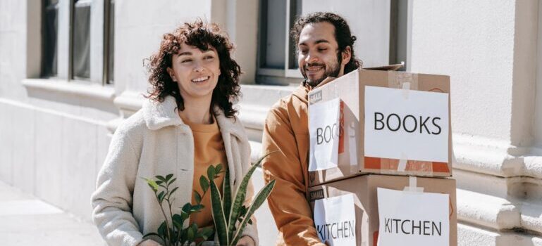 A couple holding boxes and waiting for movers Fairfield CT offers