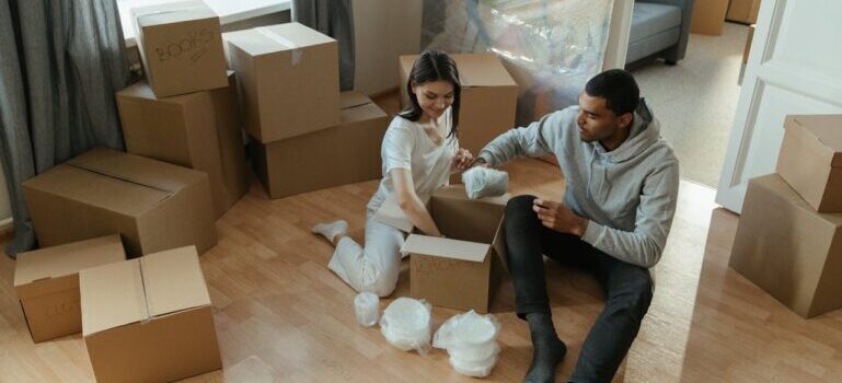 man and woman packing items into boxes