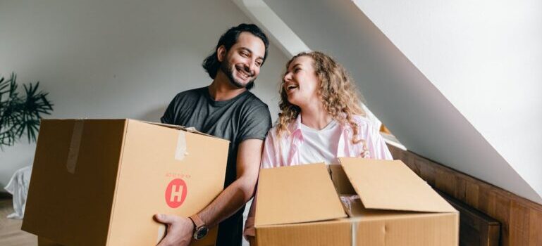 A couple holding boxes and waiting for movers Trumbull CT provides