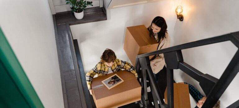 A family carrying boxes while waiting movers Monroe CT provides