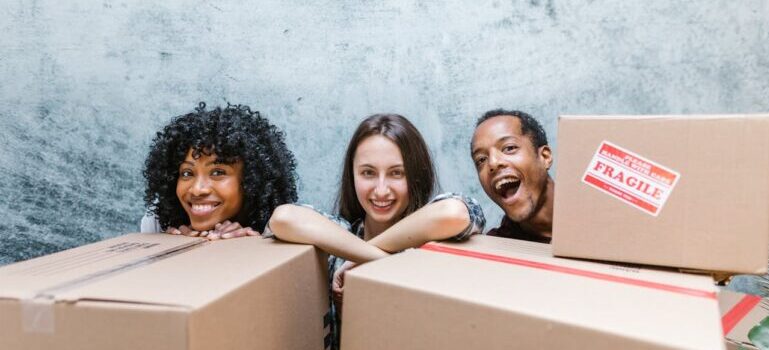 three people behind boxes waiting for movers Wilton CT offers