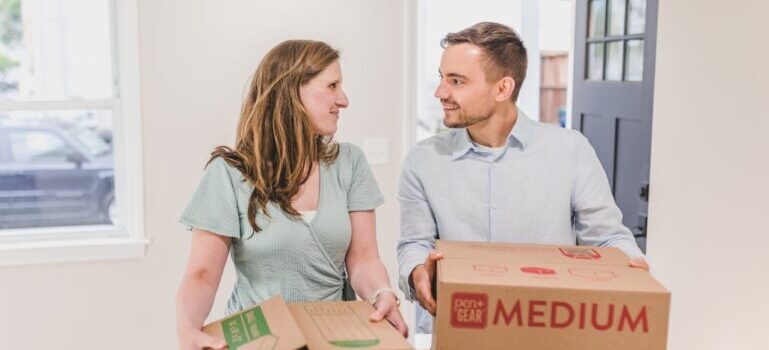 A man and a woman stepping into their new home after moving with movers New Canaan CT