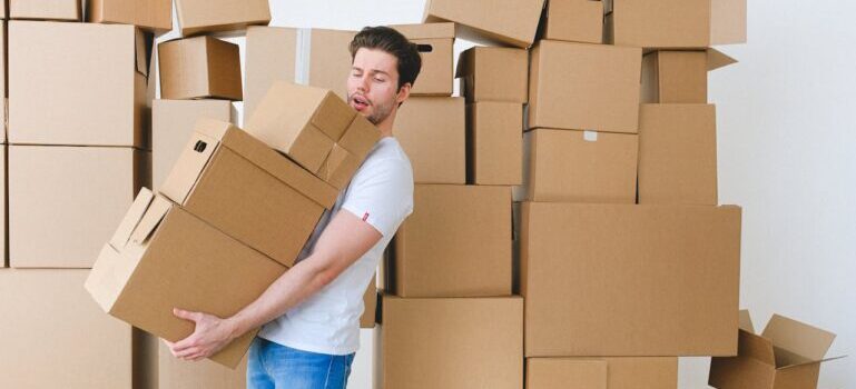 A man holding boxes while waiting for movers Hamden CT offers