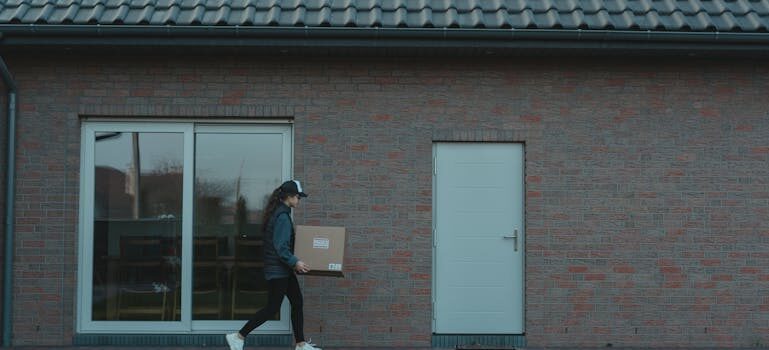 A woman carrying a moving box