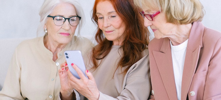 Three women using a phone