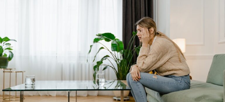 worried woman sitting on a couch