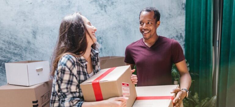 man and woman carrying boxes