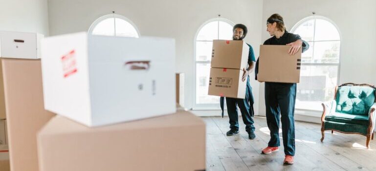 two men carrying boxes and trying to prepare for a move to Monroe CT