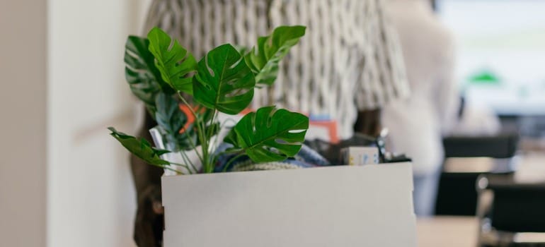 An employee holding a box with their belongings