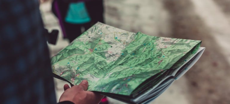 A person holding a trail map of one of the top parks in Cheshire.