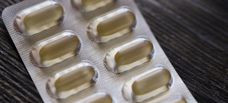 A close-up of a blister pack with pills on a wooden surface.