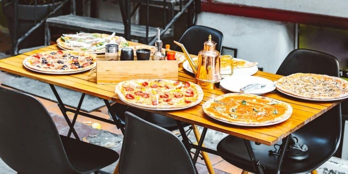 A table outside with a couple of pizzas on it in one of the best local restaurants to try after moving to Westport