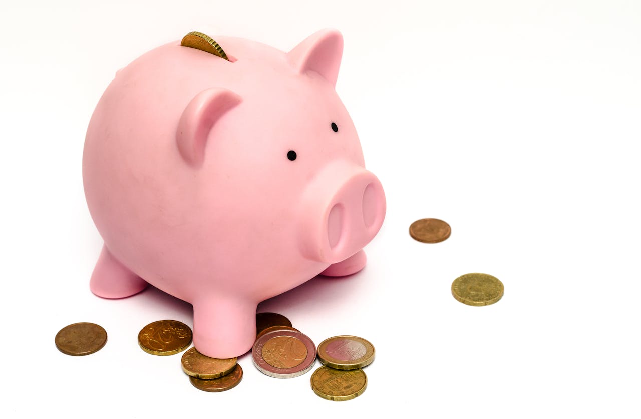 Piggy bank and coins on a white surface