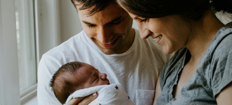 Young couple with a baby trying to decide between neighborhoods in Waterbury for families and professionals