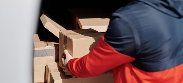 Person packing boxes into a van