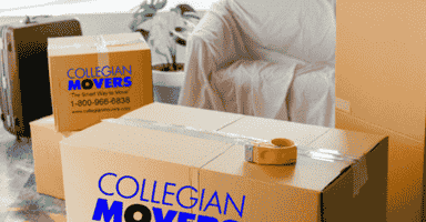 packing boxes and tape in front of a living room sofa covered with a moving blanket