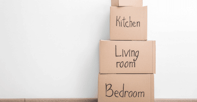 Empty room with labeled moving boxes on wall background