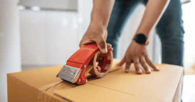 Man sealing a box with a tape gun